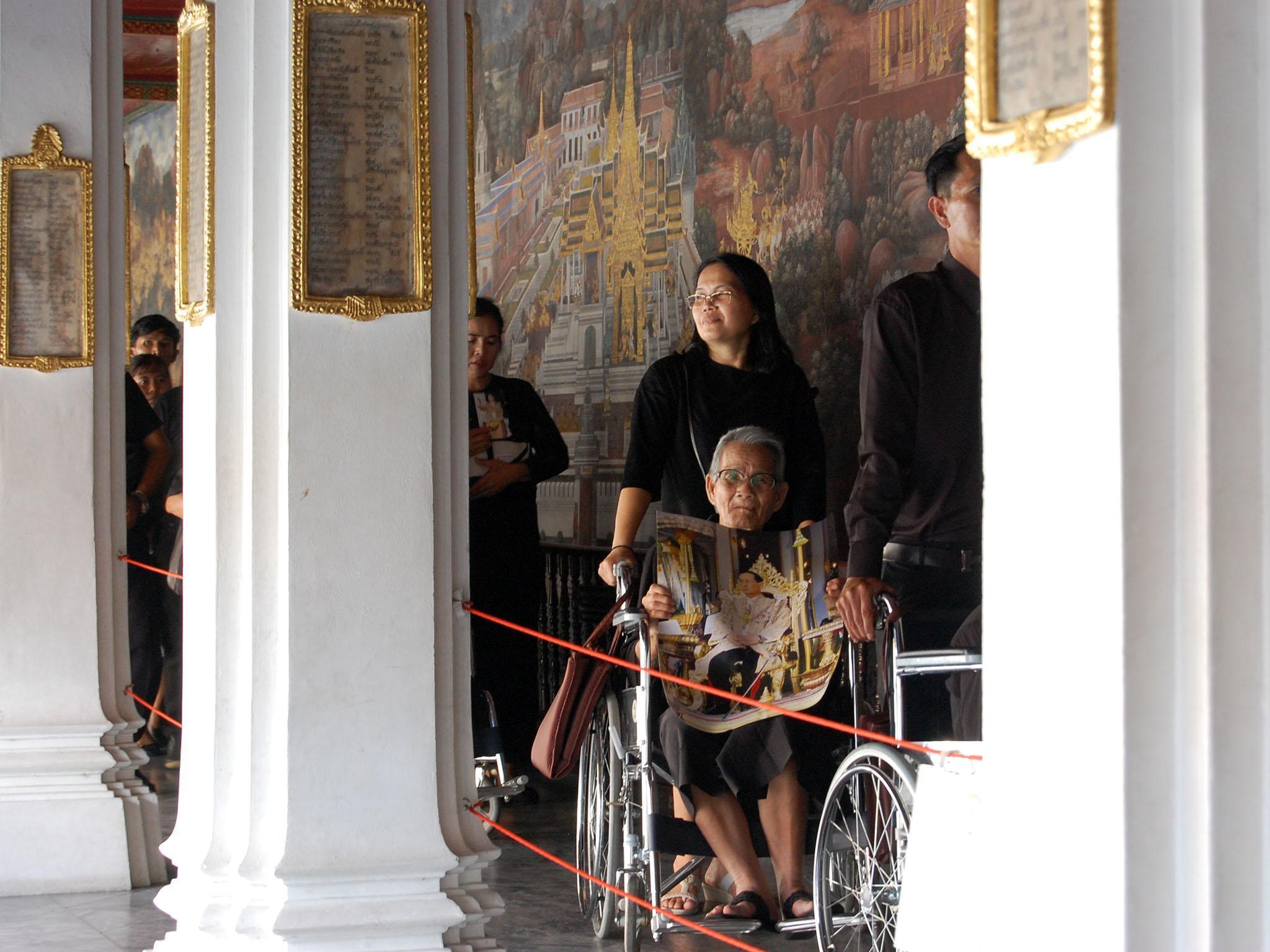 Mourners wait up to 10 hours in the blazing sun outside the Grand Palace to pay their respects to the dead king