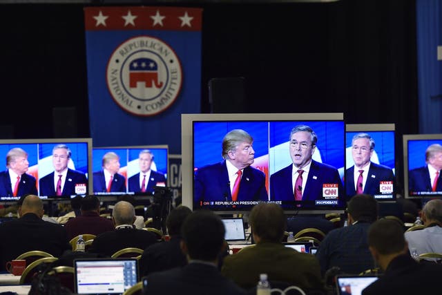 Republican U.S. presidential candidates businessman Donald Trump and former Governor Jeb Bush are seen debating on video monitors in the press room during the Republican presidential debate in Las Vegas