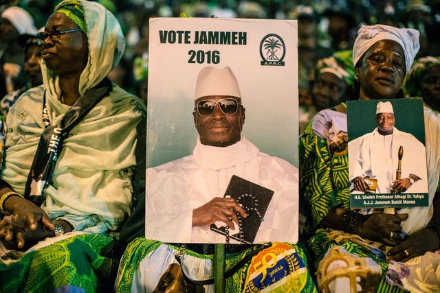 Supporters of incumbent President Yahya Jammeh sit at a campaign rally on 29 November 2016