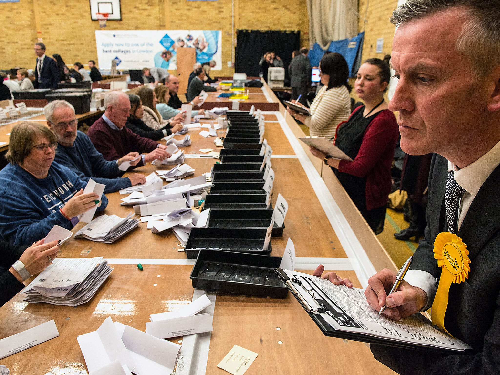 A counting agent for Liberal Democrat candidate Sarah Olney watches over count staff during the Richmond Park by-election count at Richmond Upon Thames College