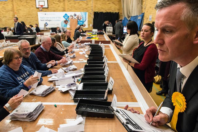 A counting agent for Liberal Democrat candidate Sarah Olney watches over count staff during the Richmond Park by-election count at Richmond Upon Thames College