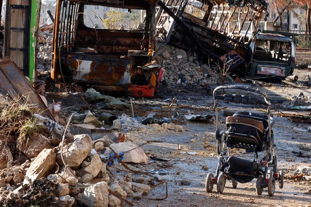An abandoned pushchair near destroyed vehicles used as barricades by rebels in Hanano, Aleppo, on 2 December