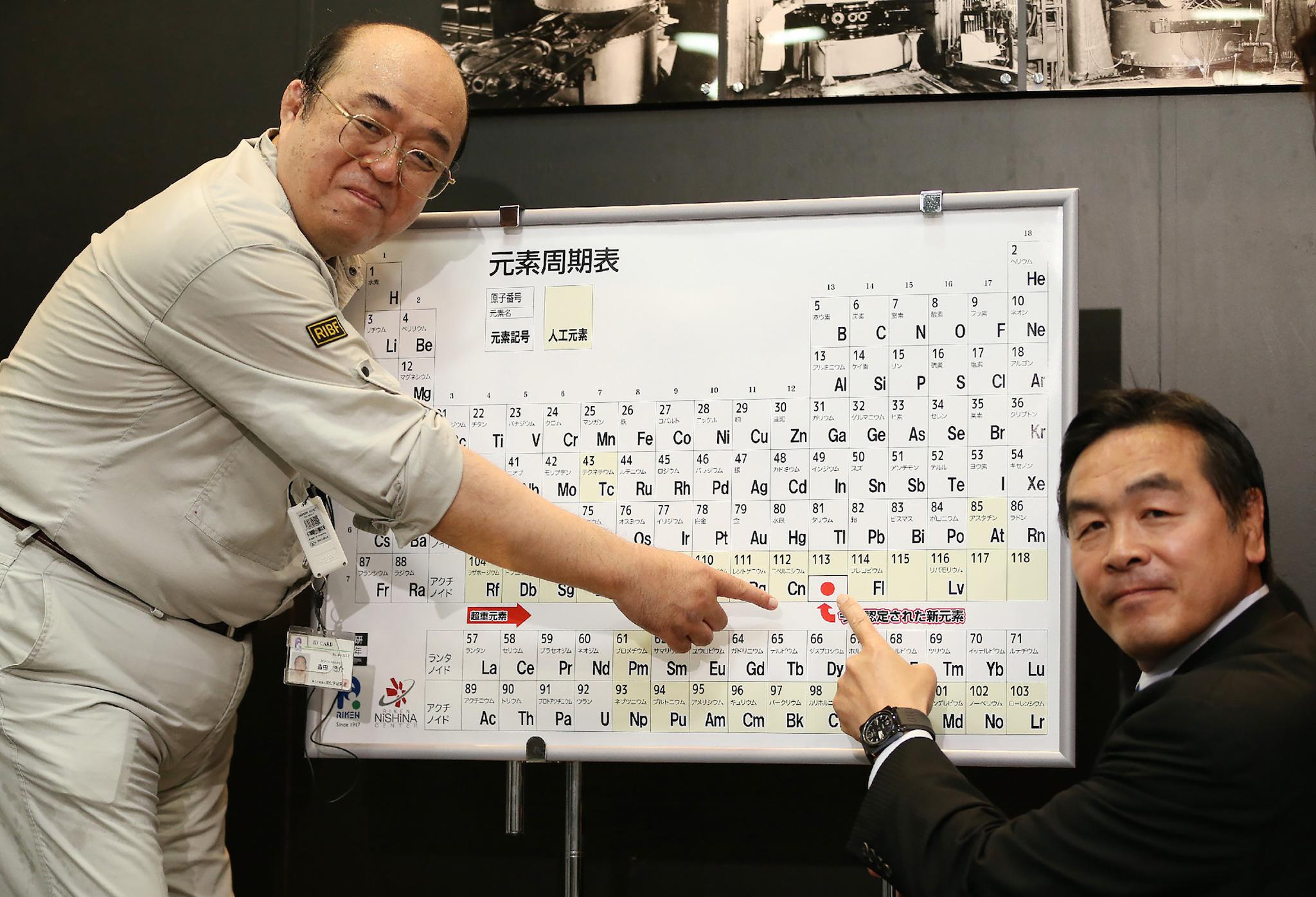 Kosuke Morita (L), who led the team at Riken institute that discovered the superheavy synthetic element, and Hiroshi Hase (R), Minister of Education, Culture, Sports, Science and Technology, pose with a board displaying the new element 113 during at a press conference at Riken's research center in Wako, Saitama prefecture on June 9, 2016