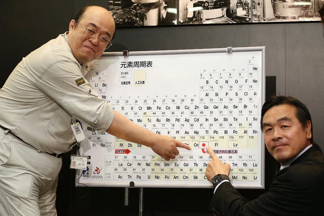 Kosuke Morita (L), who led the team at Riken institute that discovered the superheavy synthetic element, and Hiroshi Hase (R), Minister of Education, Culture, Sports, Science and Technology, pose with a board displaying the new element 113 during at a press conference at Riken's research center in Wako, Saitama prefecture on June 9, 2016