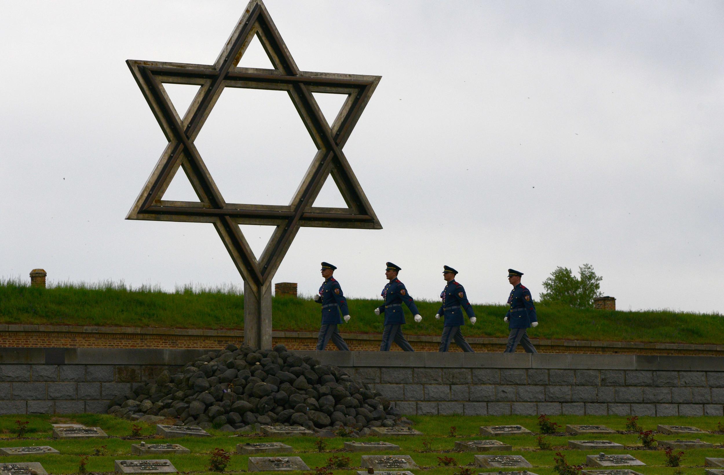 Czech soldiers walk past a memorial cemetery at the former Terezin concentration camp