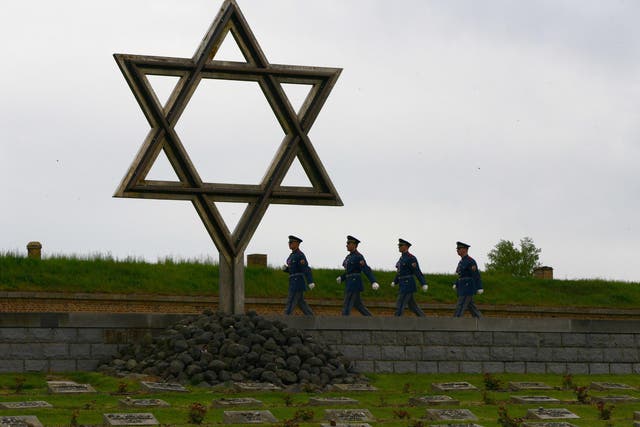 Czech soldiers walk past a memorial cemetery at the former Terezin concentration camp