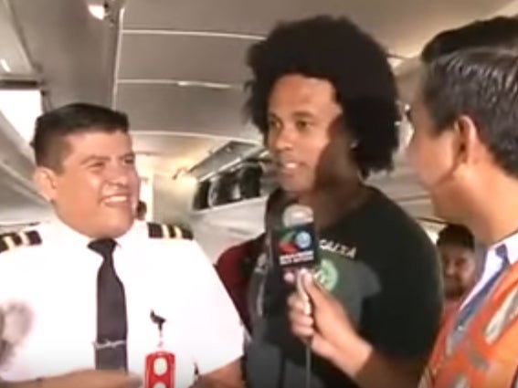 Cabin crew and striker Everton dos Santos Goncalves are interviewed before takeoff