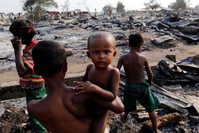 Boys stand among debris after fire destroyed shelters at a camp for internally displaced Rohingya Muslims in the western Rakhine State near Sittwe, Myanmar