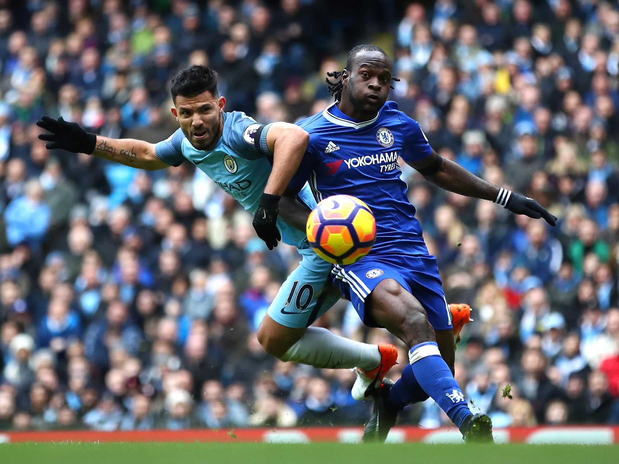 Sergio Aguero tussles for the ball with Victor Moses