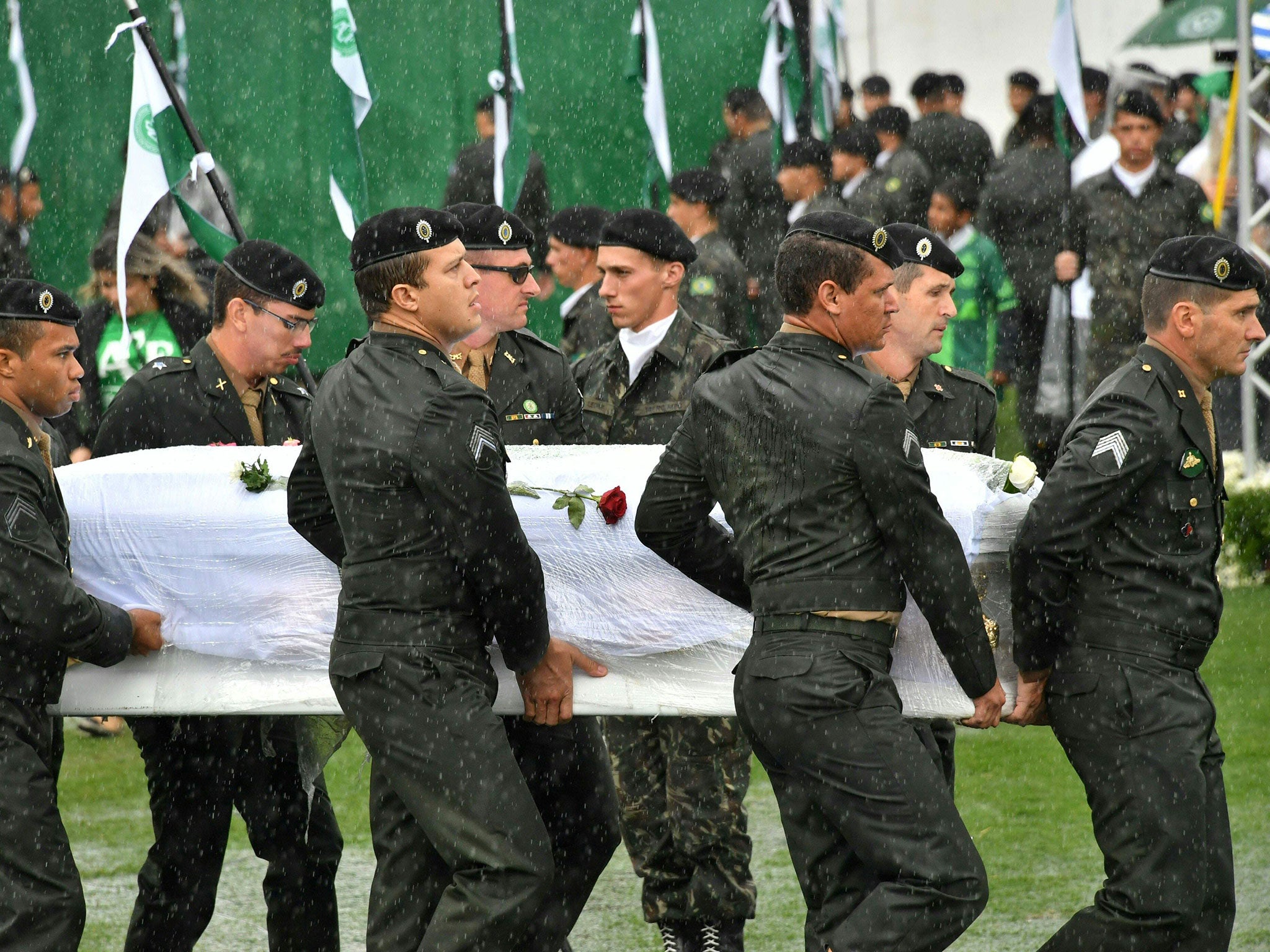 Soldiers carry coffins of Chapecoense Real footballers who were killed in a plane crash in Colombia into their home stadium in Brazil on 3 December