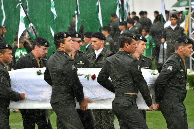 Soldiers carry coffins of Chapecoense Real footballers who were killed in a plane crash in Colombia into their home stadium in Brazil on 3 December