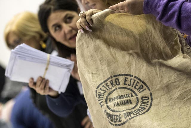Electoral staff unload and open bags containing the ballots of Italians living abroad