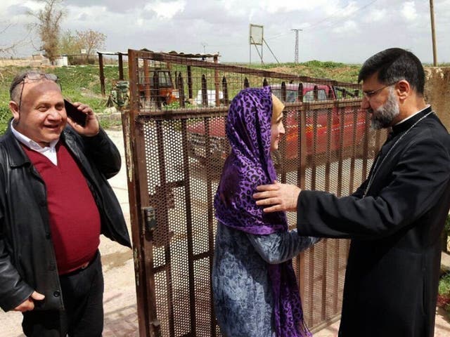 Assyrian Christian bishop Mar Afram Athneil, right, greets Maryam David Thalya after her release from more than a year of captivity by Isis
