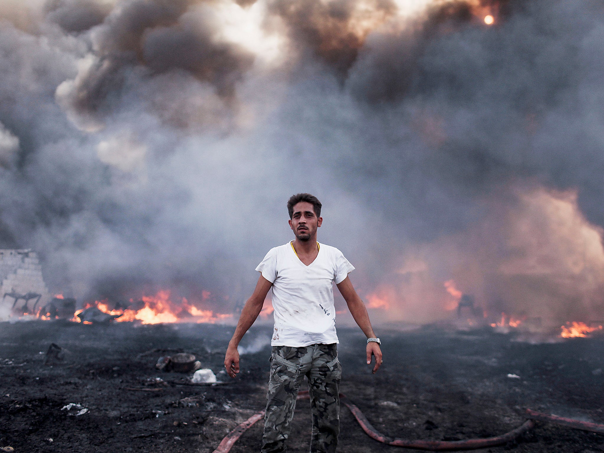 A destroyed plastic factory burns in the Khatba district of Tripoli in September 2011, where Qaddafi loyalists and rebels battled for Libya’s capital city