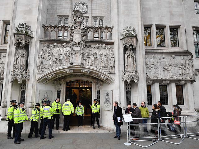 Police officers stand guard outside the Supreme court in London on the second day of a four-day hearing