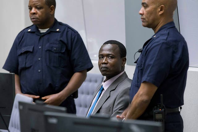Dominic Ongwen, a senior commander in the Lord's Resistance Army, whose fugitive leader Kony is one of the world's most-wanted war crimes suspects, is flanked by two security guards as he sits in the court room of the International Court in The Hague, Netherlands