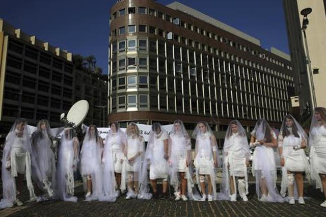 Women dresses as brides wrapped in bloody bandages protest the law in Beirut