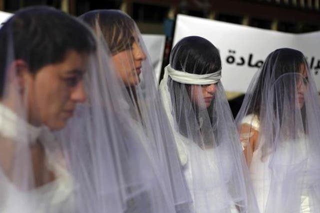 Women dressed as brides in bloodstained white dresses protest existing rape legislation outside the government building in downtown Beirut, Lebanon, on December 6 2016
