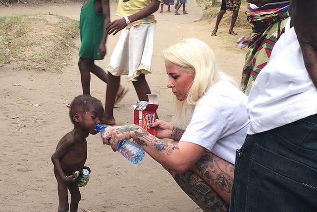 Anja Ringgren Loven gives water to Hope, 2, after finding the emaciated boy wandering the streets in Nigeria