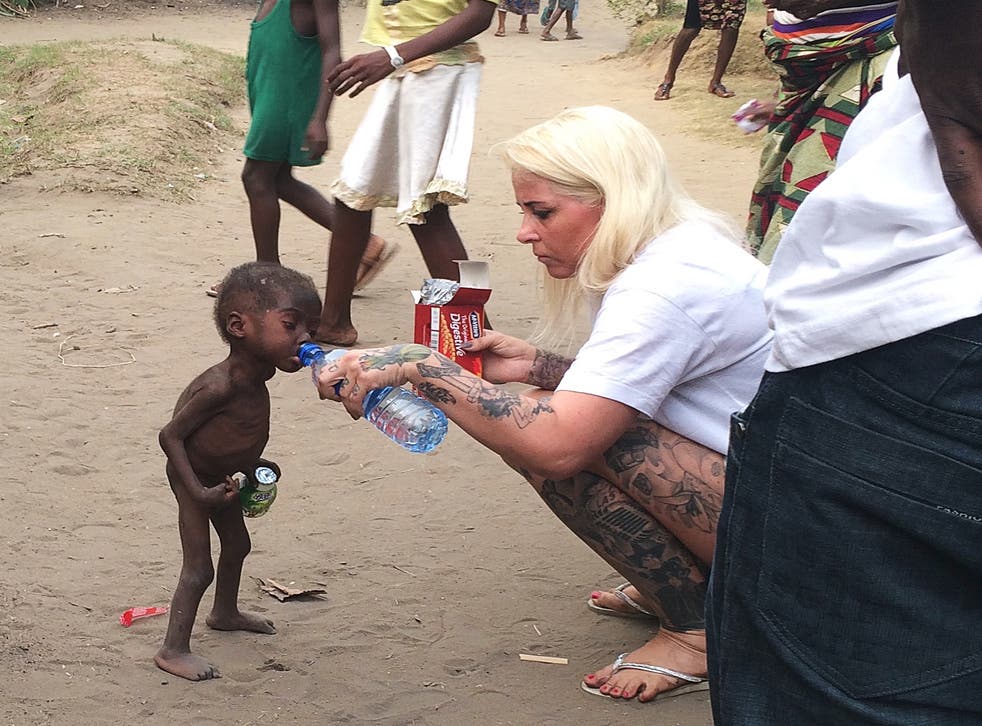 Anja Ringgren Loven gives water to Hope, 2, after finding the emaciated boy wandering the streets in Nigeria