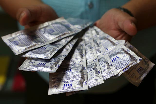 A Filipino health worker shows condoms that are given for free to the public by the Department of Health in Manila, Philippines