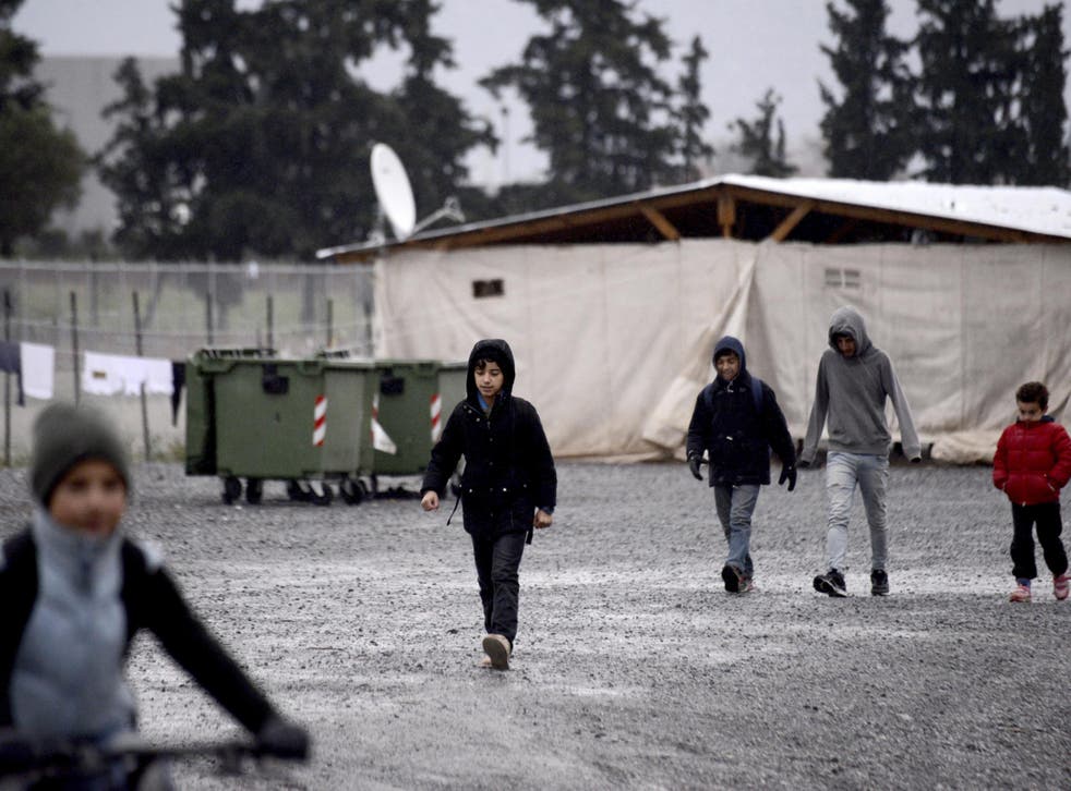 Children walk inside a refugee camp near the northern Greek city of Thessaloniki