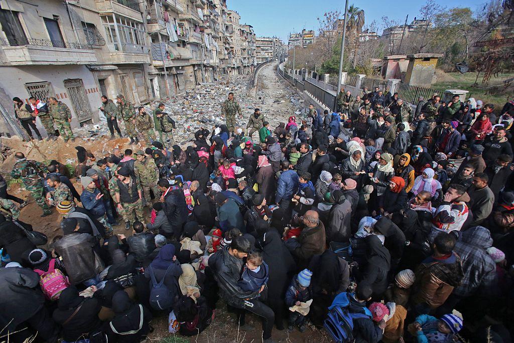 East Aleppo residents flee the violence at a checkpoint manned by pro-government forces in Maysaloun, Aleppo, on December 8 2016