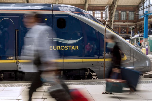 <p>Travellers pass by an Eurostar train at Lille’s train station</p>