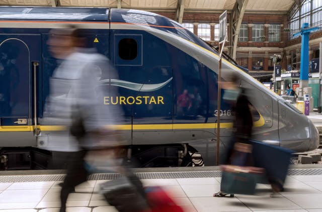 <p>Travellers pass by an Eurostar train at Lille’s train station</p>