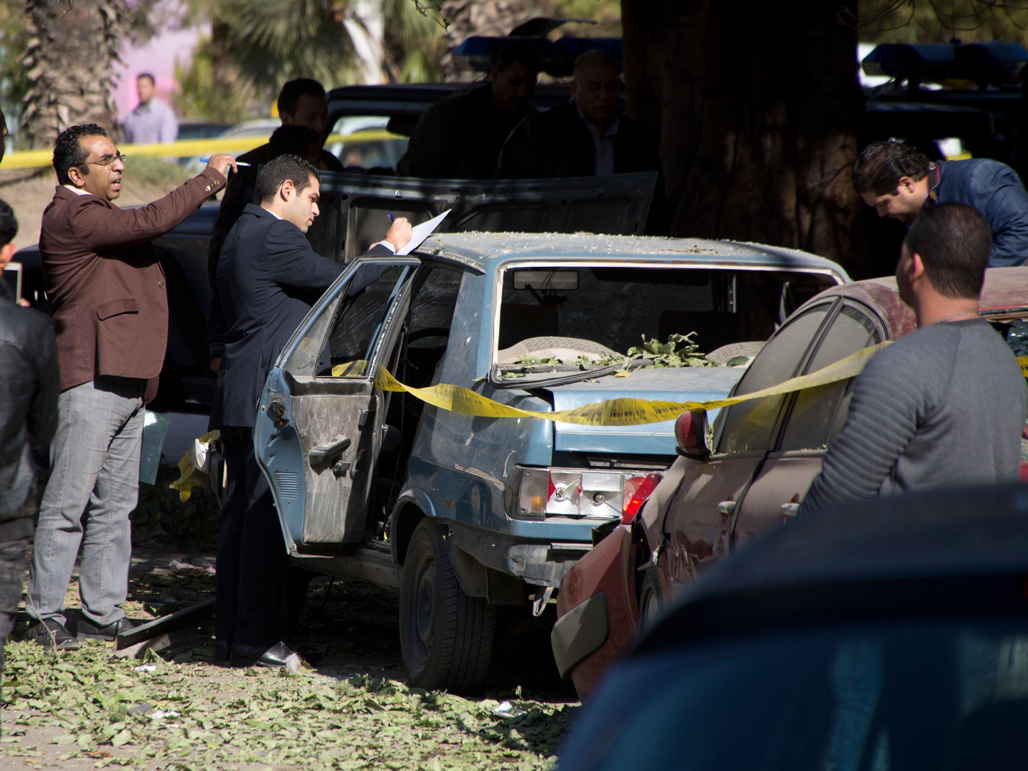 Egyptian explosives experts look for evidence at the site of a bomb explosion in Cairo, Egypt, on 9 December