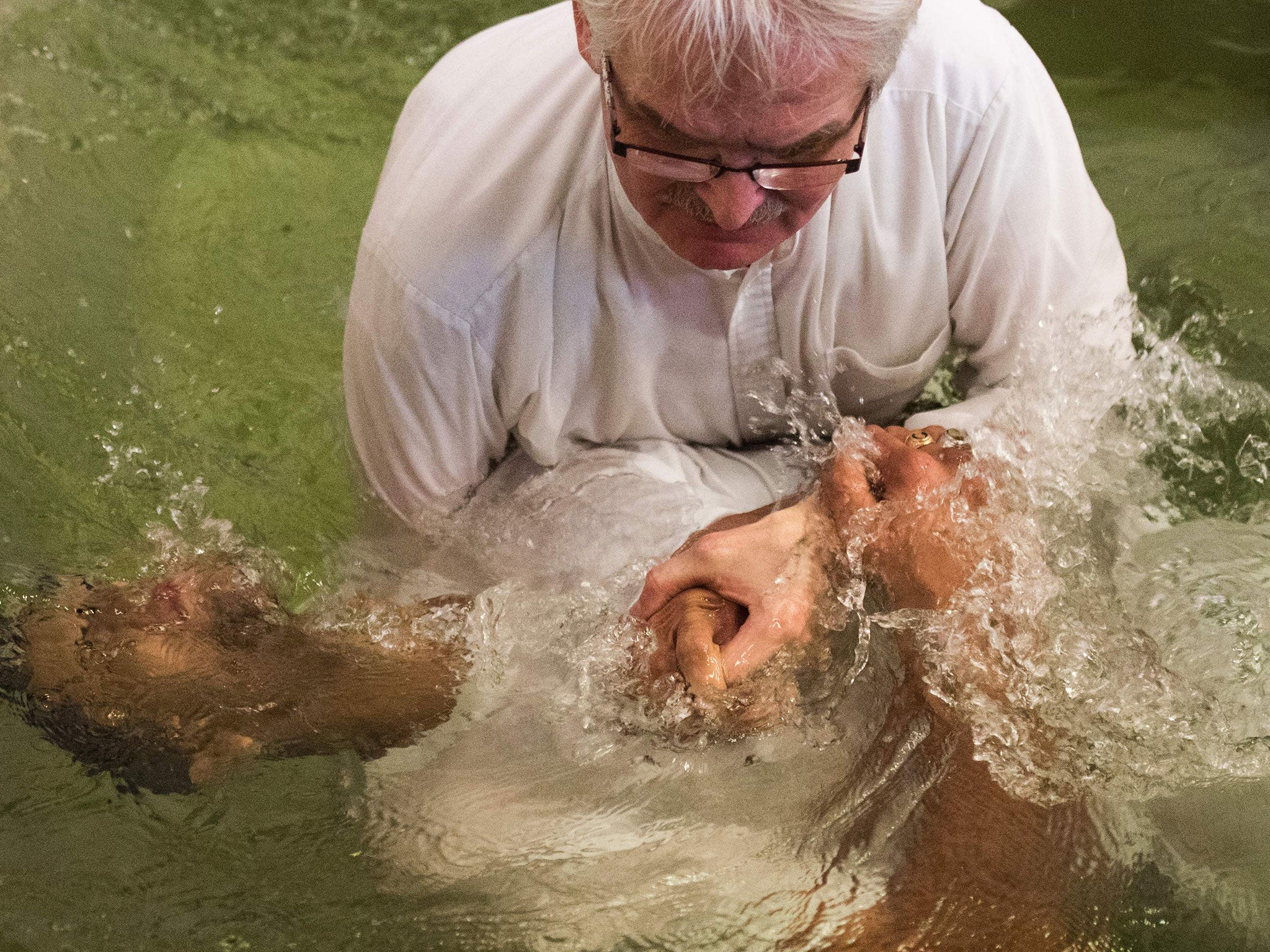 Pastor Matthias Linke of the Evangelisch-Freikirchliche Gemeinde church baptises a newly converted Muslim refugee during a ceremony in Berlin on 27 November