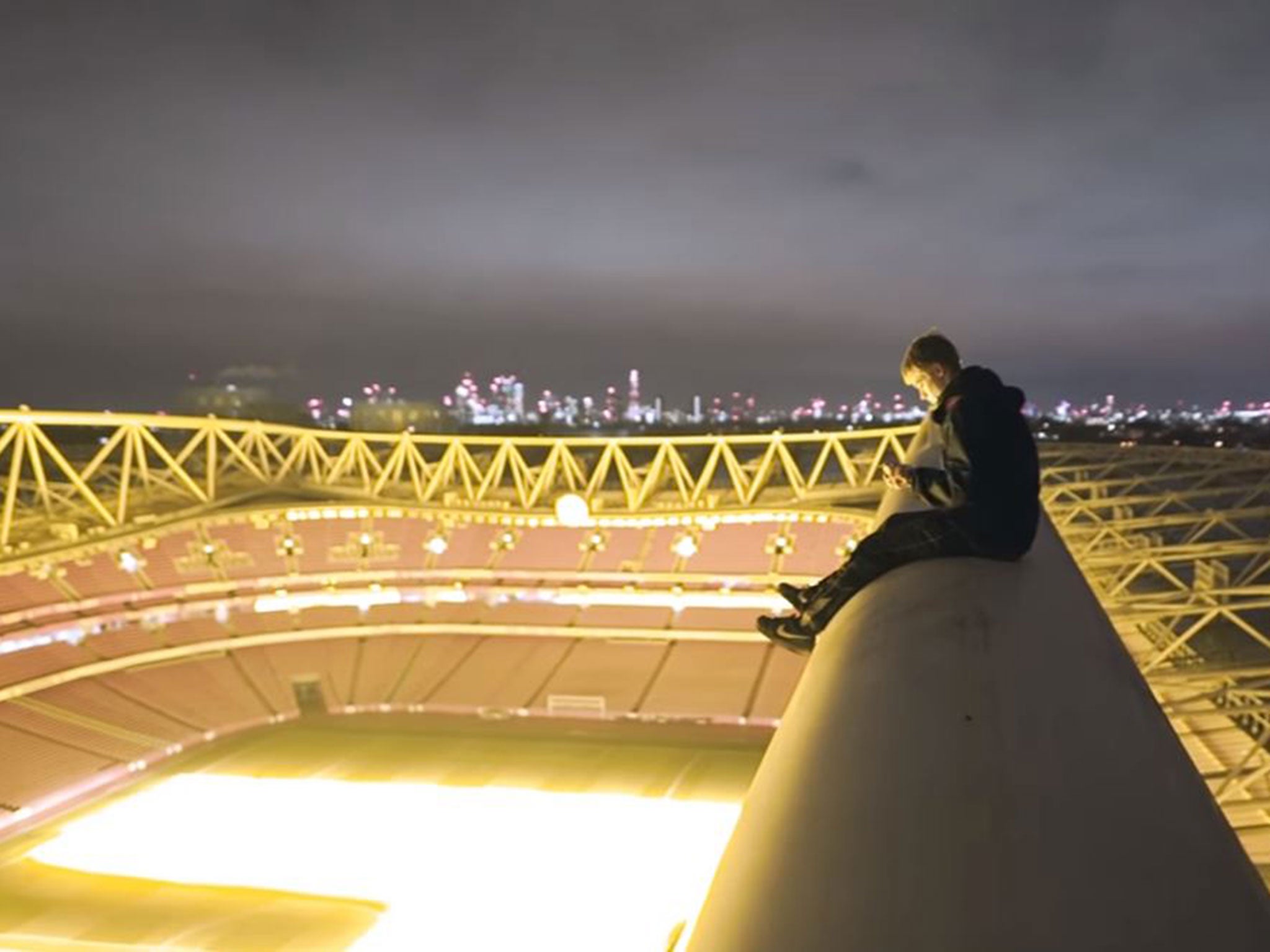The YouTuber sits atop the Emirates Stadium with the London skyline visible in the background