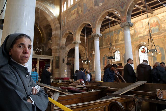 A nun stands inside the damaged St. Peter and St. Paul Coptic Orthodox Church after a bombing in Cairo, Egypt