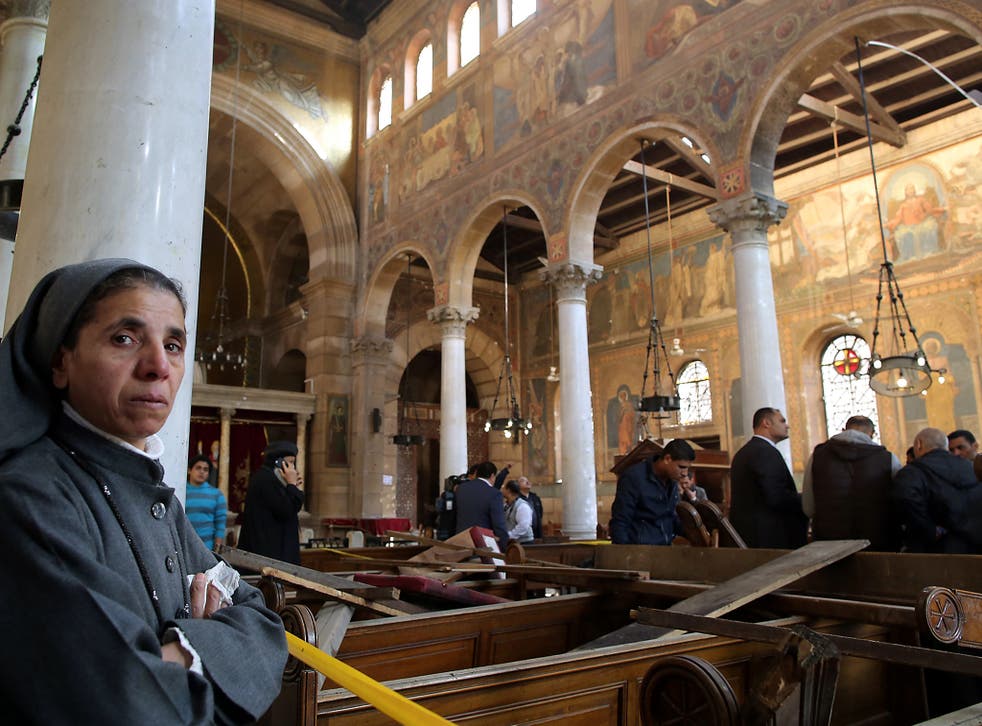 A nun stands inside the damaged St. Peter and St. Paul Coptic Orthodox Church after a bombing in Cairo, Egypt
