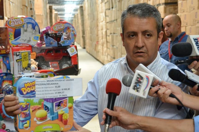 William Contreras, the head of the Venezualan agency charged with battling price-fixing, poses with some of the 4 million impounded toys