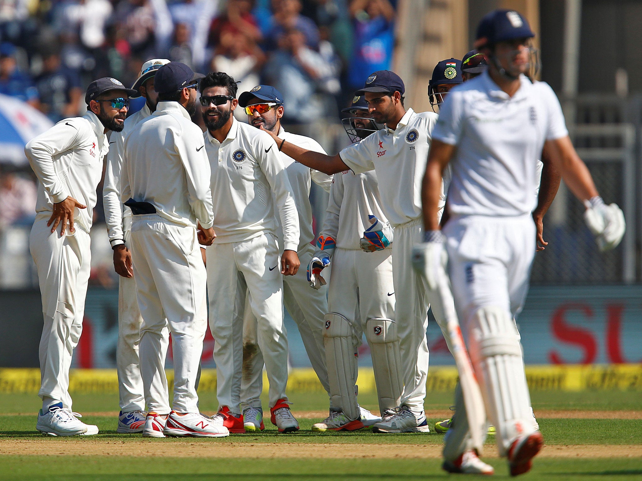 India's players celebrate Cook's dismissal