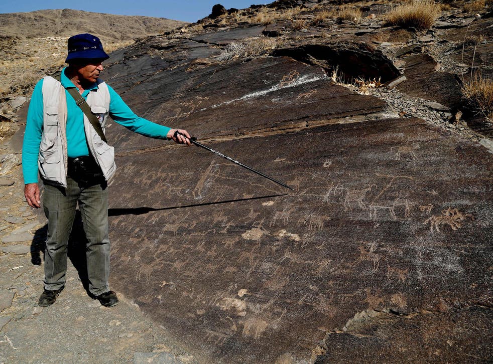 Iranian archeologist Mohammed Naserifard displays ancient engravings in the hills outside the town of Khomeyn