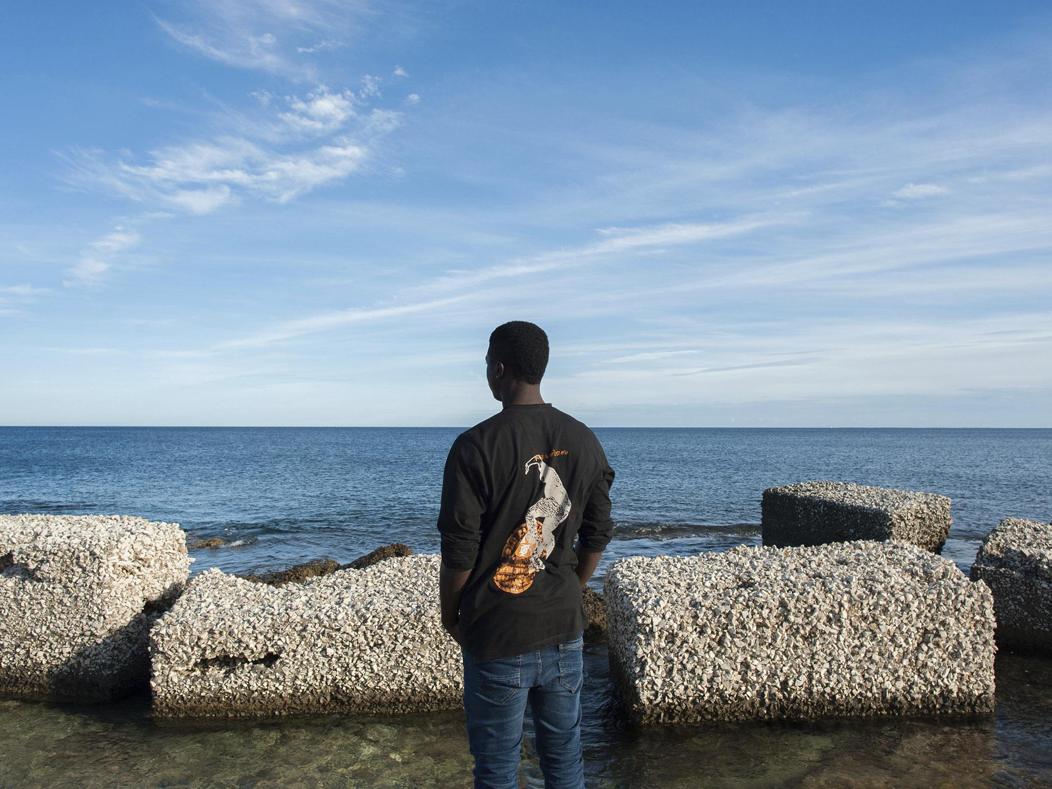 Samie watches the sea in Pachino, Sicily. The Togolese migrant is struggling to find out what happened to his fiancée