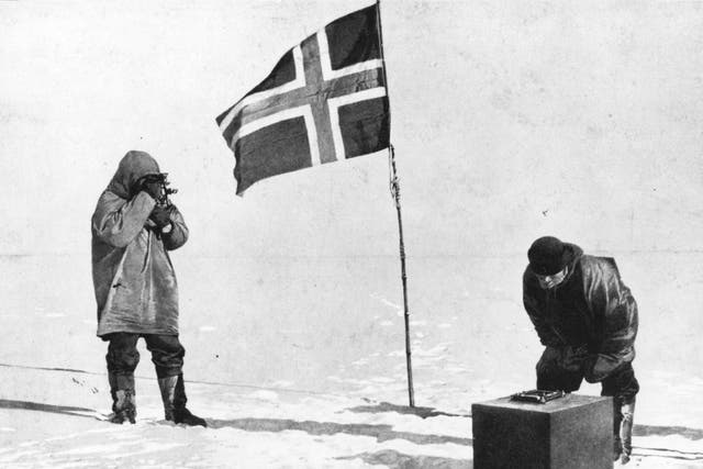Roald Amundsen taking in the sights at the South Pole, beside the Norwegian flag