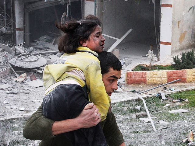 A Syrian man carries his sister who was wounded after a government airstrike hit the neighborhood of Ansari, in Aleppo, Syria