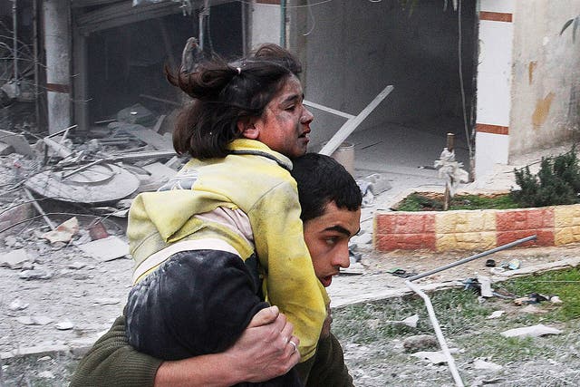 A Syrian man carries his sister who was wounded after a government airstrike hit the neighborhood of Ansari, in Aleppo, Syria