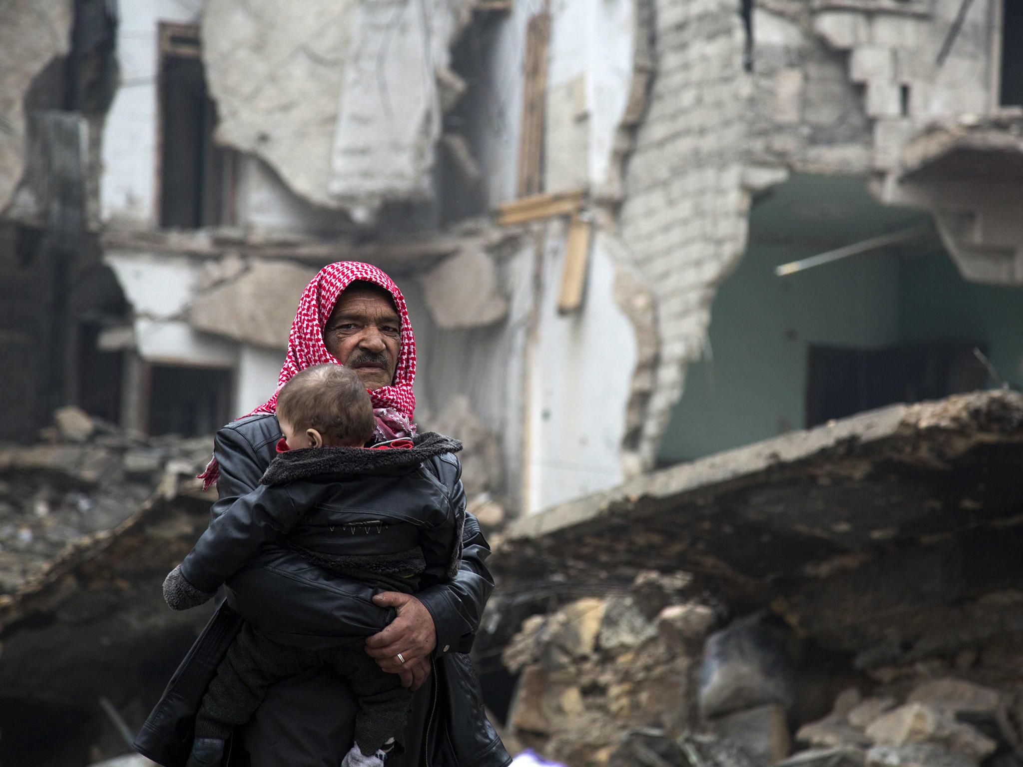 Syrians leave a rebel-held area of Aleppo towards the government-held side on 13 December