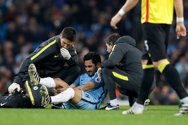 Ilkay Gundogan receives treatment after injuring his knee
