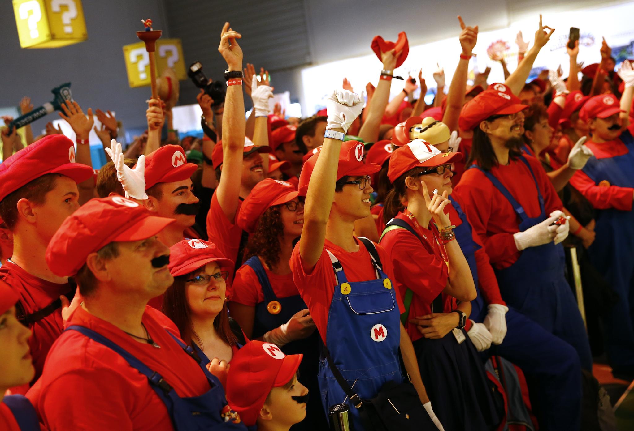 Cosplayers dressed as character "Mario" celebrate the 30th anniversary of "Super Mario Bros." video games developed by Nintendo during the Gamescom 2015 fair in Cologne, Germany August 6, 2015