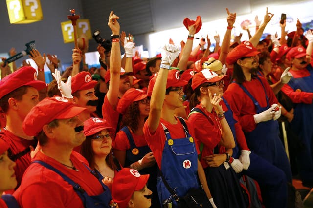 Cosplayers dressed as character "Mario" celebrate the 30th anniversary of "Super Mario Bros." video games developed by Nintendo during the Gamescom 2015 fair in Cologne, Germany August 6, 2015