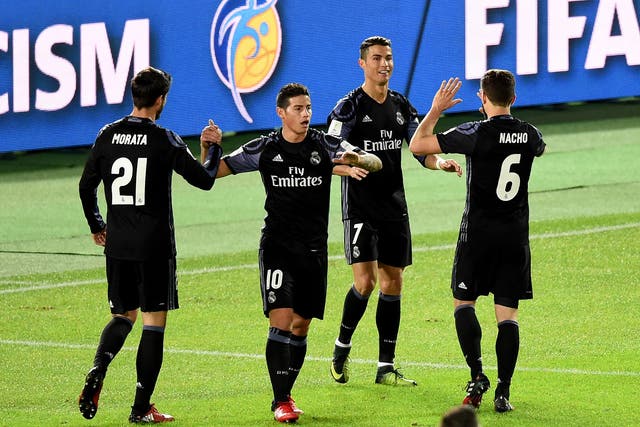 Real Madrid's players congratulate Cristiano Ronaldo on his late goal at the Nissan Stadium