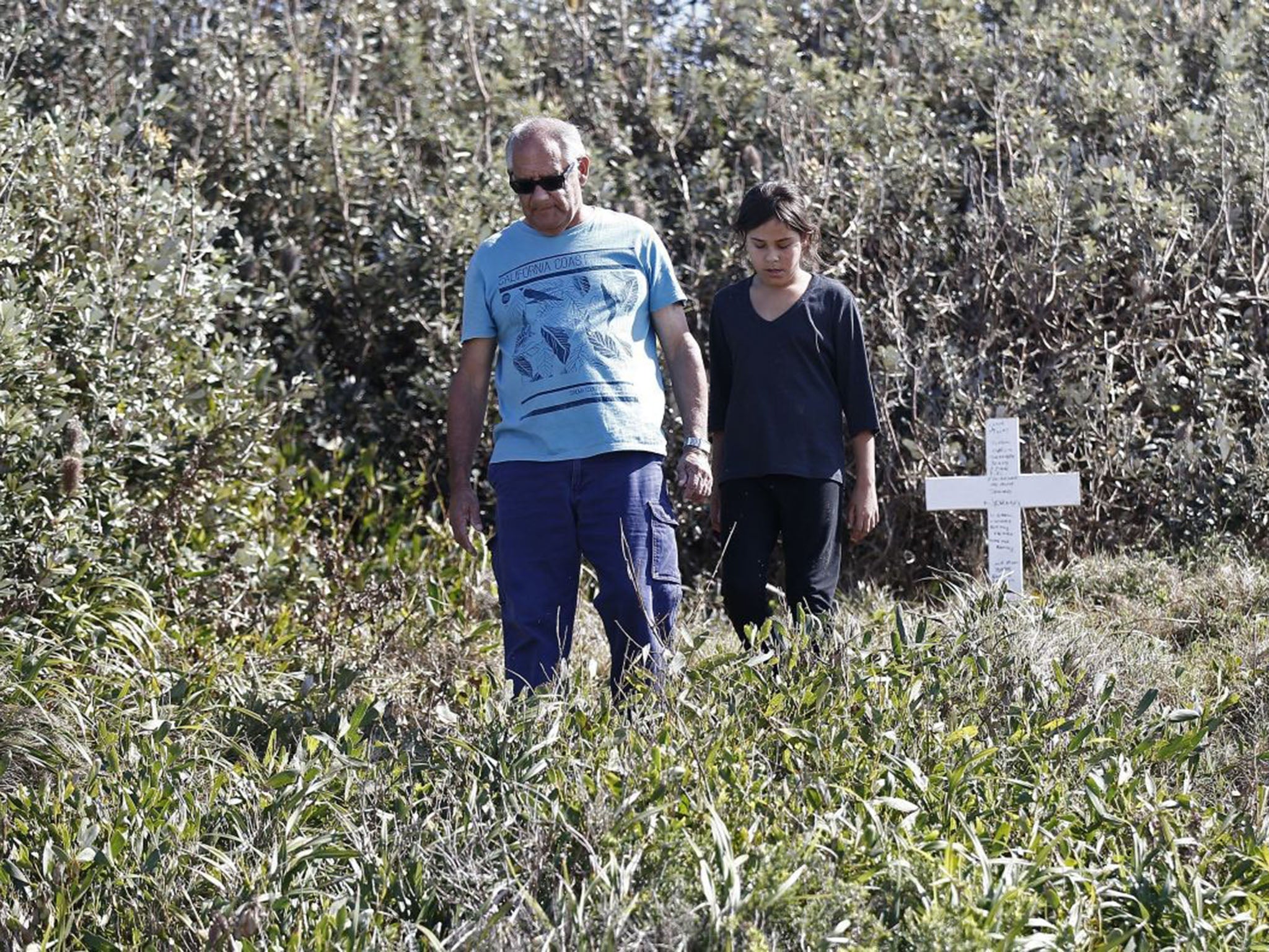 Lynette's stepfather Gordon and youngest daughter Alana visit a memorial cross dedicated to her