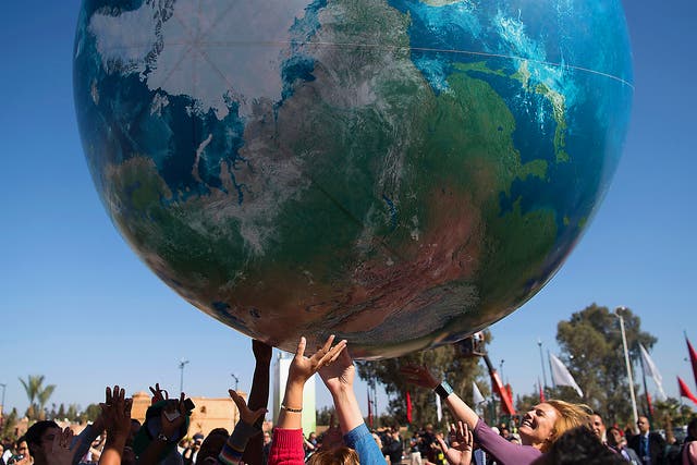 Members of International delegations play with a giant air globe ball outside the COP22 climate conference in Marrakesh