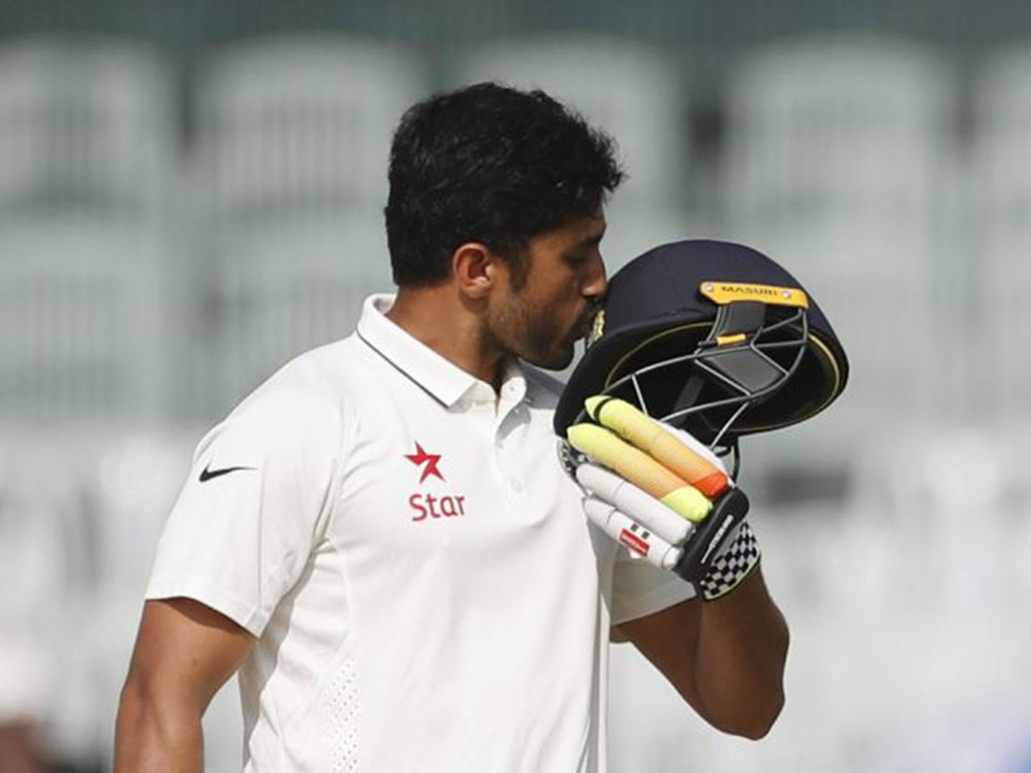 Karun Nair kisses the badge on his helmet after reaching his double century