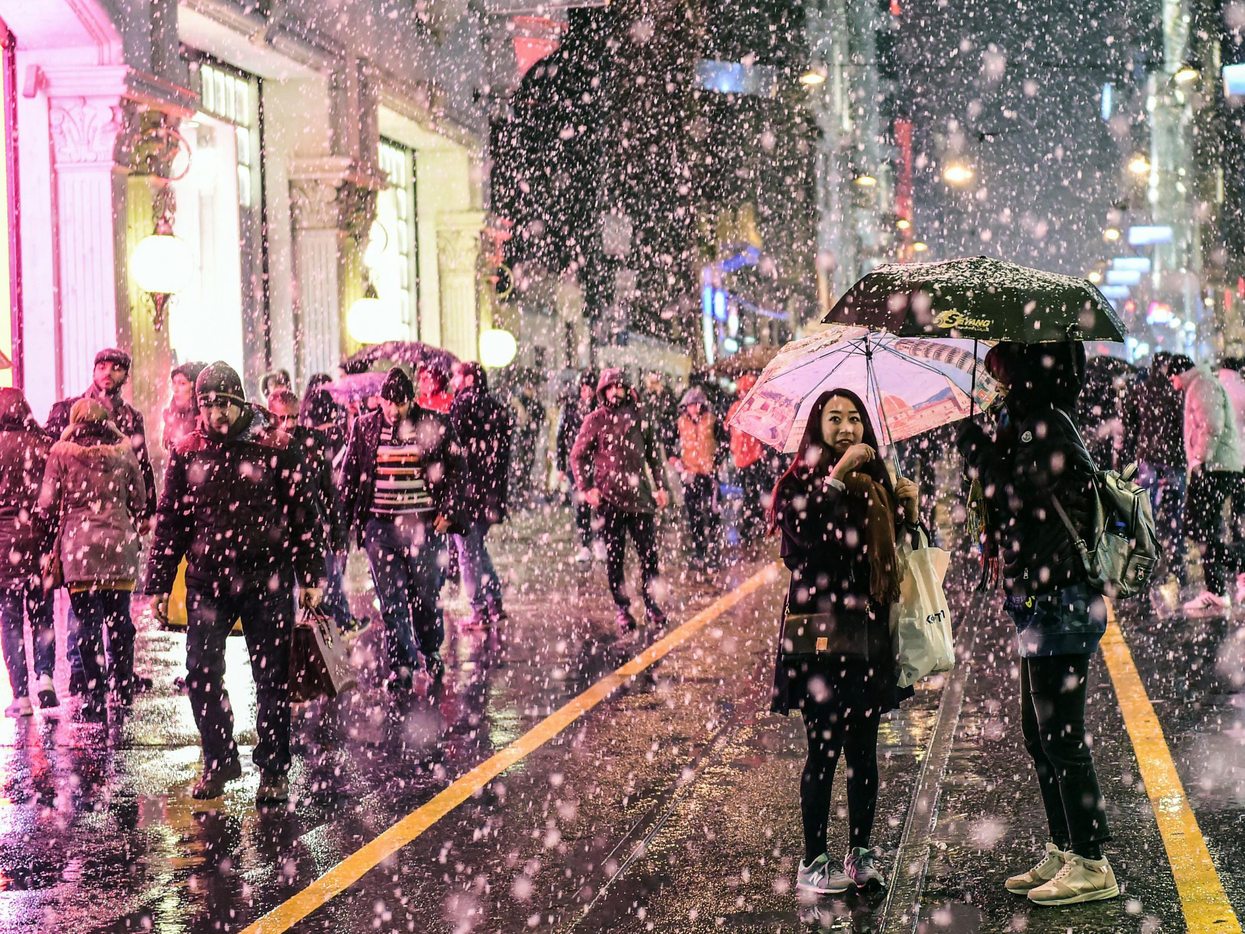 People walk along Istiklal Avenue as snow falls in Istanbul